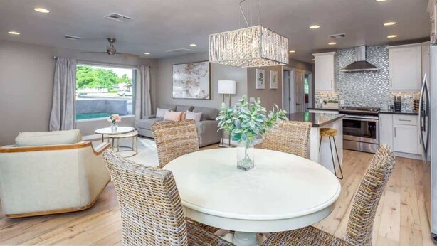 A modern living room with a round table, wicker chairs, a sofa, and a dining area. - Modern Living, A Fav! Firepit, BBQ, Min to Airport (Phoenix)