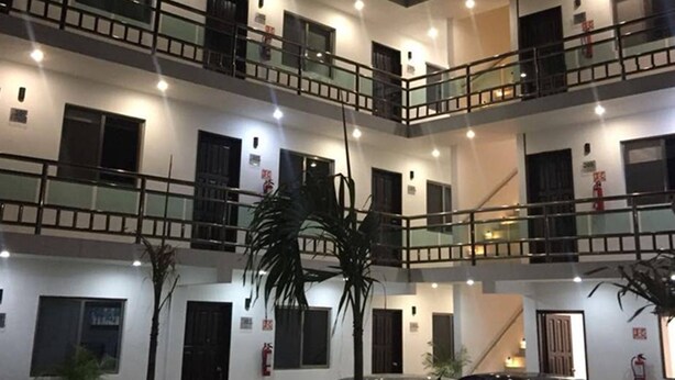 A multi-story building with balconies, windows, and fire safety equipment. - Hotel Apartamentos Stone (Bacalar)