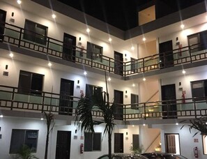 A multi-story building with balconies, windows, and fire safety equipment. - Hotel Apartamentos Stone (Bacalar)