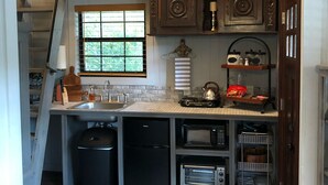 A compact kitchen with a built-in oven, a sink, and a window.