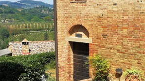 A brick building with a window and an arched entrance.