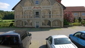 A hotel with a stone facade and a sign that reads "Mellon-Hotel Aragon Restaurant." - Aragon am Lennepark (Ahrensfelde)