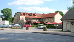 A hotel with a red-tiled roof, a signboard, and a parking area. - Aragon am Lennepark (Ahrensfelde)