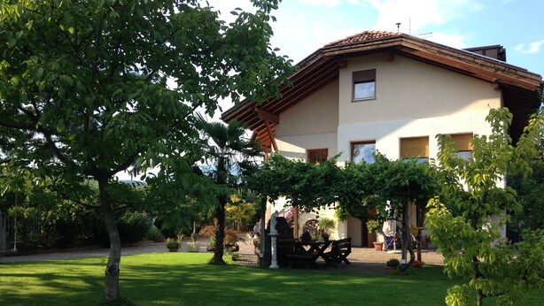 Ein Haus mit Garten, einer Pergola und einer Terrasse.