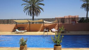 A swimming pool with lounge chairs and palm trees. - Elegant Gueliz Retreat near Majorelle (Marrakech)