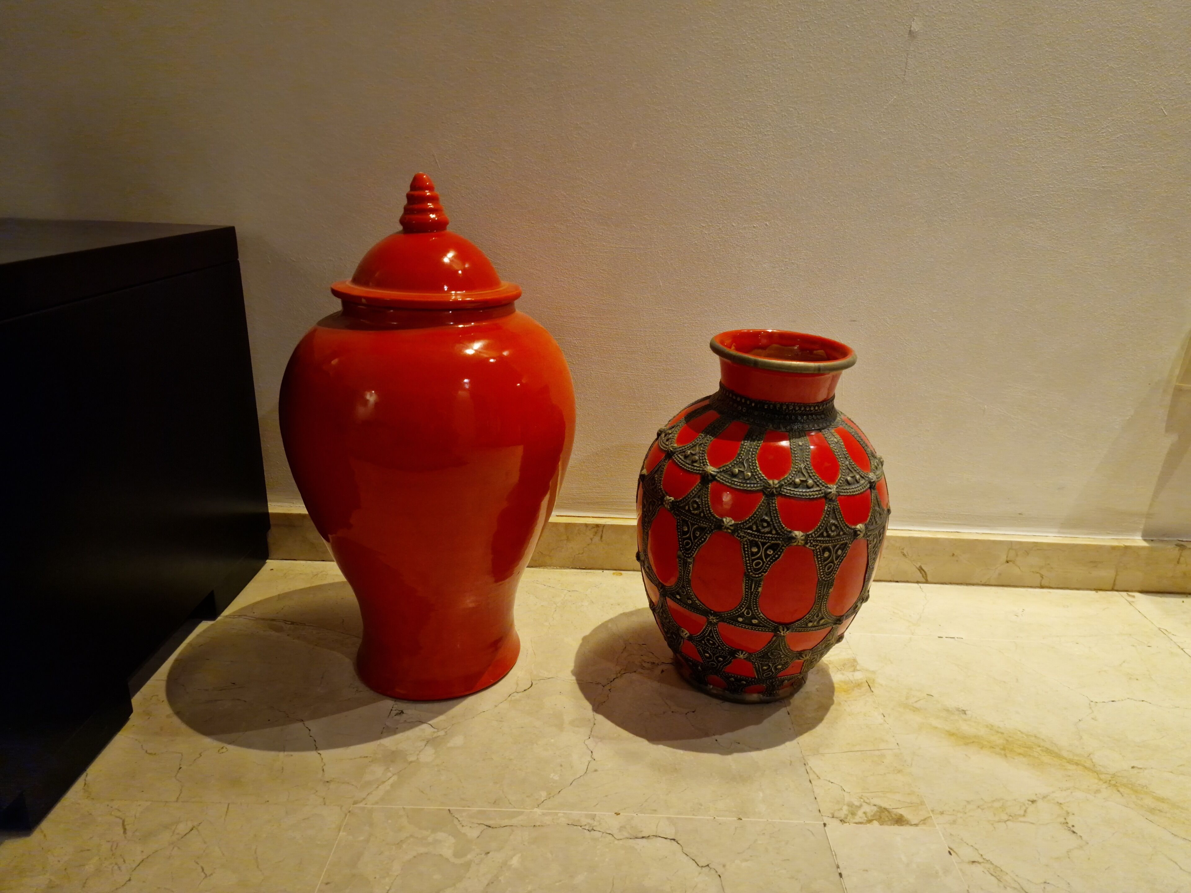 Two ceramic vases on a tiled surface.