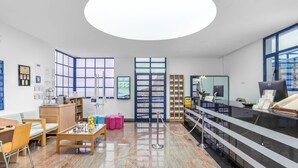Una zona de recepción con mostrador, sillas, una mesa de centro y una vitrina de cristal.