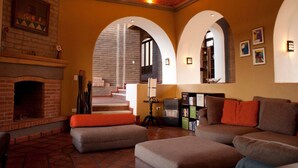 A living room with a fireplace, sofas, and a staircase leading to an upper level. - El Faro de Guanajuato (Guanajuato)