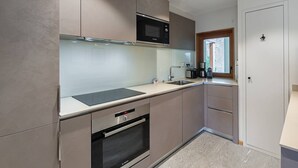 A modern kitchen with stainless steel appliances, a built-in oven, and a microwave. - Luxury flat 6 pers. - fireplace, close to the centre and slopes (CHATEL)