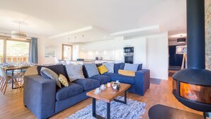 A modern living room with a sectional sofa, a dining area with a table set for four, and a kitchen in the background. - Luxury flat for 8 people - modern, close to the centre and slopes (CHATEL)