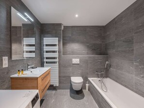 Bathtub, hair dryer, towels, toilet paper