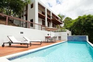 A modern pool area with lounge chairs, a table, and an umbrella. - The White Turtle Villa  ~ Marigot Bay, private pool, water views. (Marigot Bay)