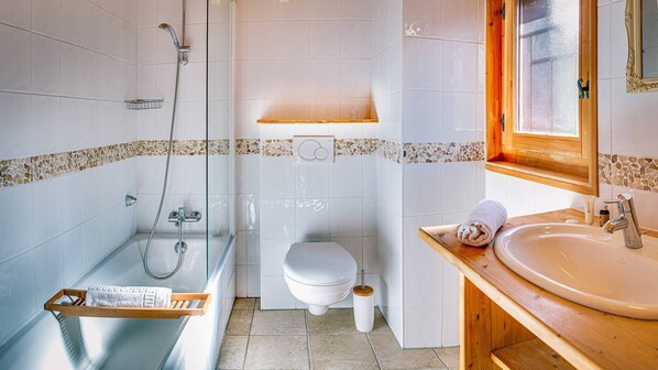 A bathroom with a bathtub, toilet, and sink.