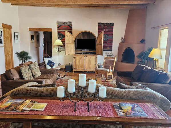Una sala de estar acogedora con chimenea, muebles de madera y televisor.