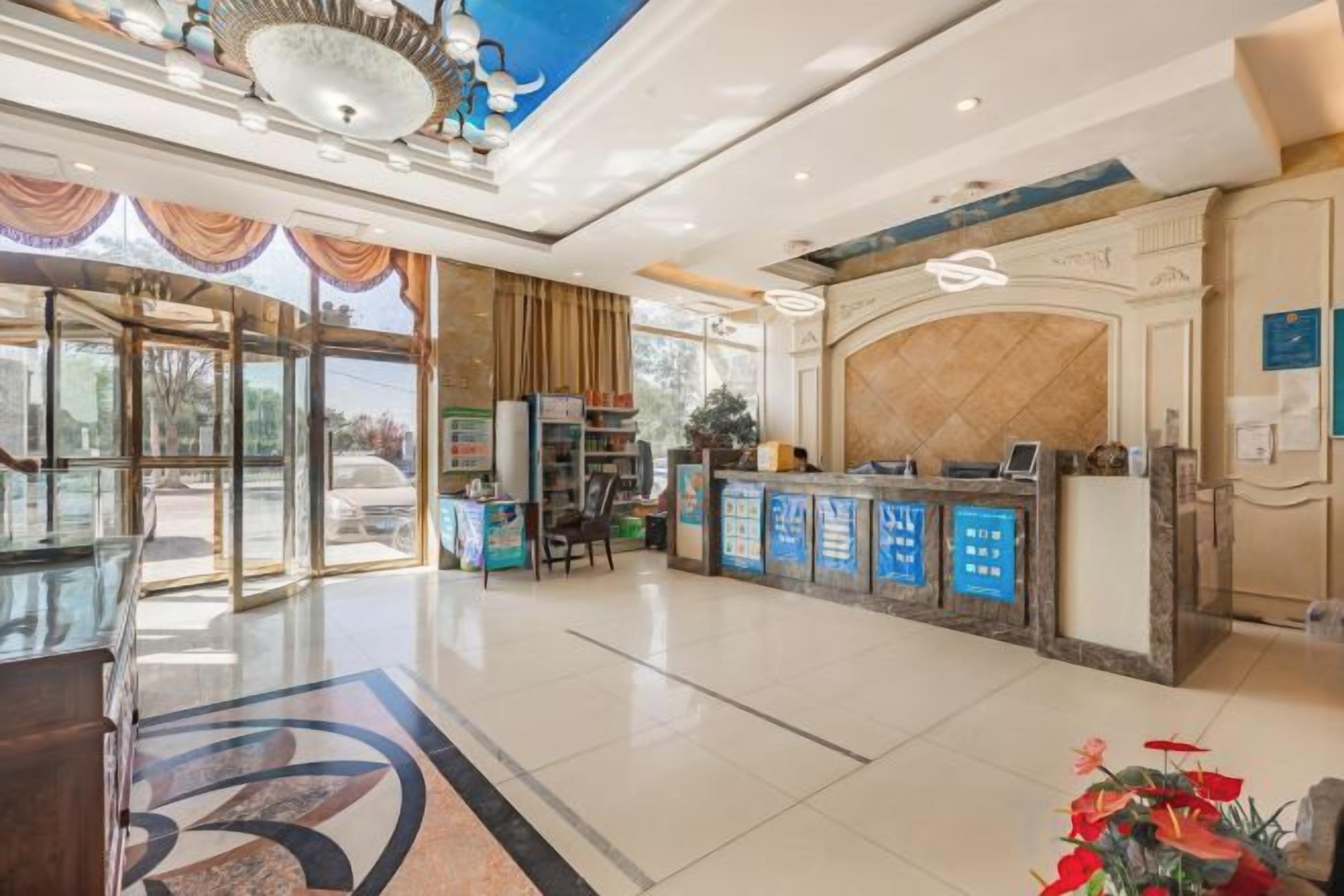 A hotel lobby with a reception desk, a glass partition, and a reception area.