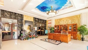 A spacious lobby with a high ceiling, a chandelier, a reception desk, and a large mural. - Zhanhang Business Hotel (Beijing Capital Airport New International Exhibition) (Beijing)