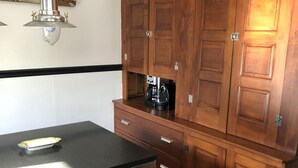 Eine Küche mit Holzschränken, einer schwarzen Arbeitsplatte und einer Kaffeemaschine.