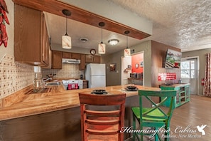 Enjoy cooking in this well-equipped kitchen with a spacious island, sink, and stove.