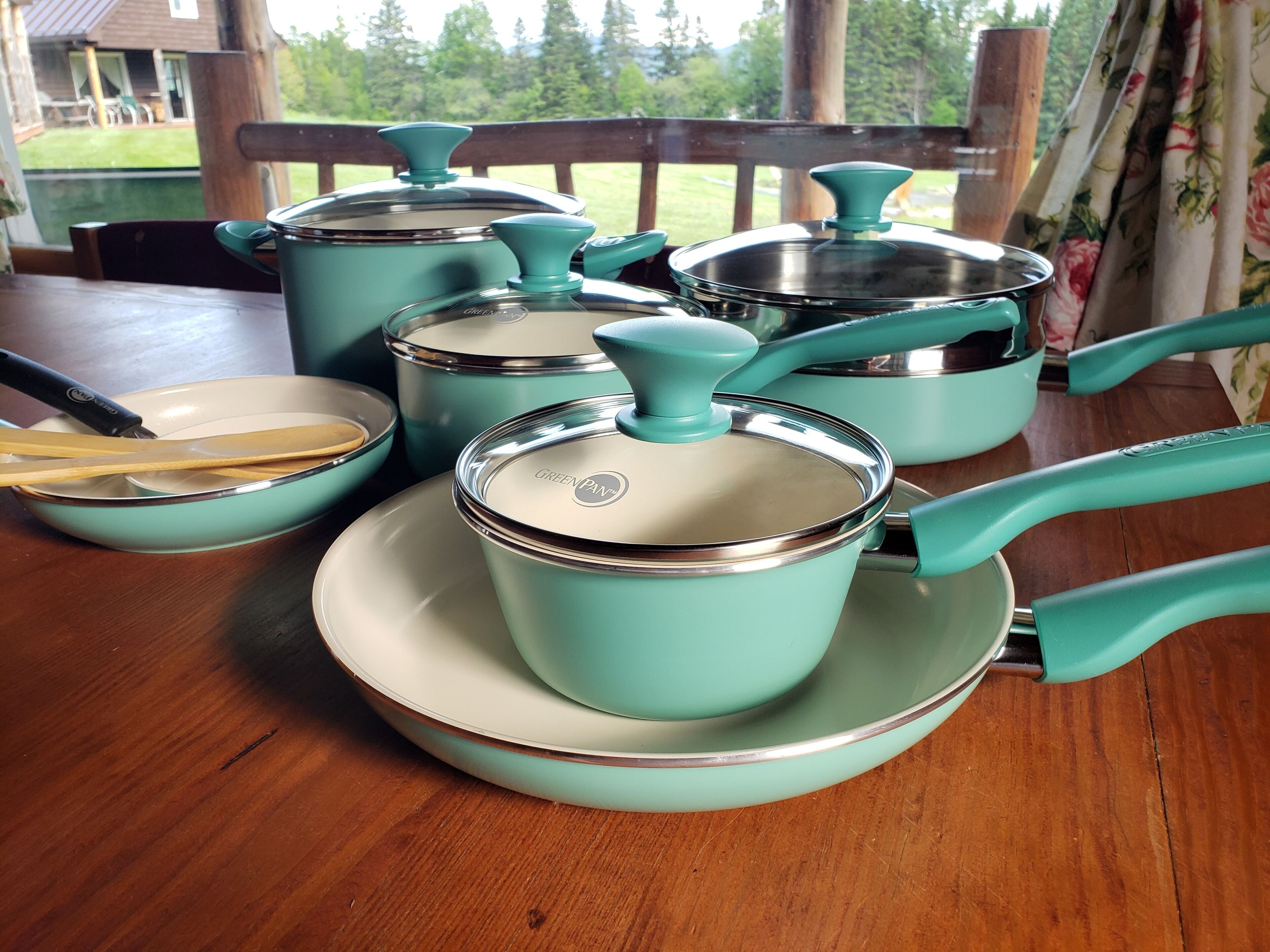 Un ensemble d’ustensiles de cuisine de couleur turquoise, posé sur une table en bois.