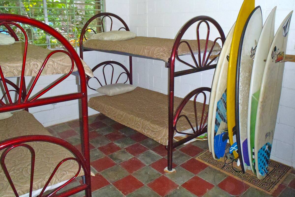 Une chambre de dortoir avec des lits superposés et des planches de surf.
