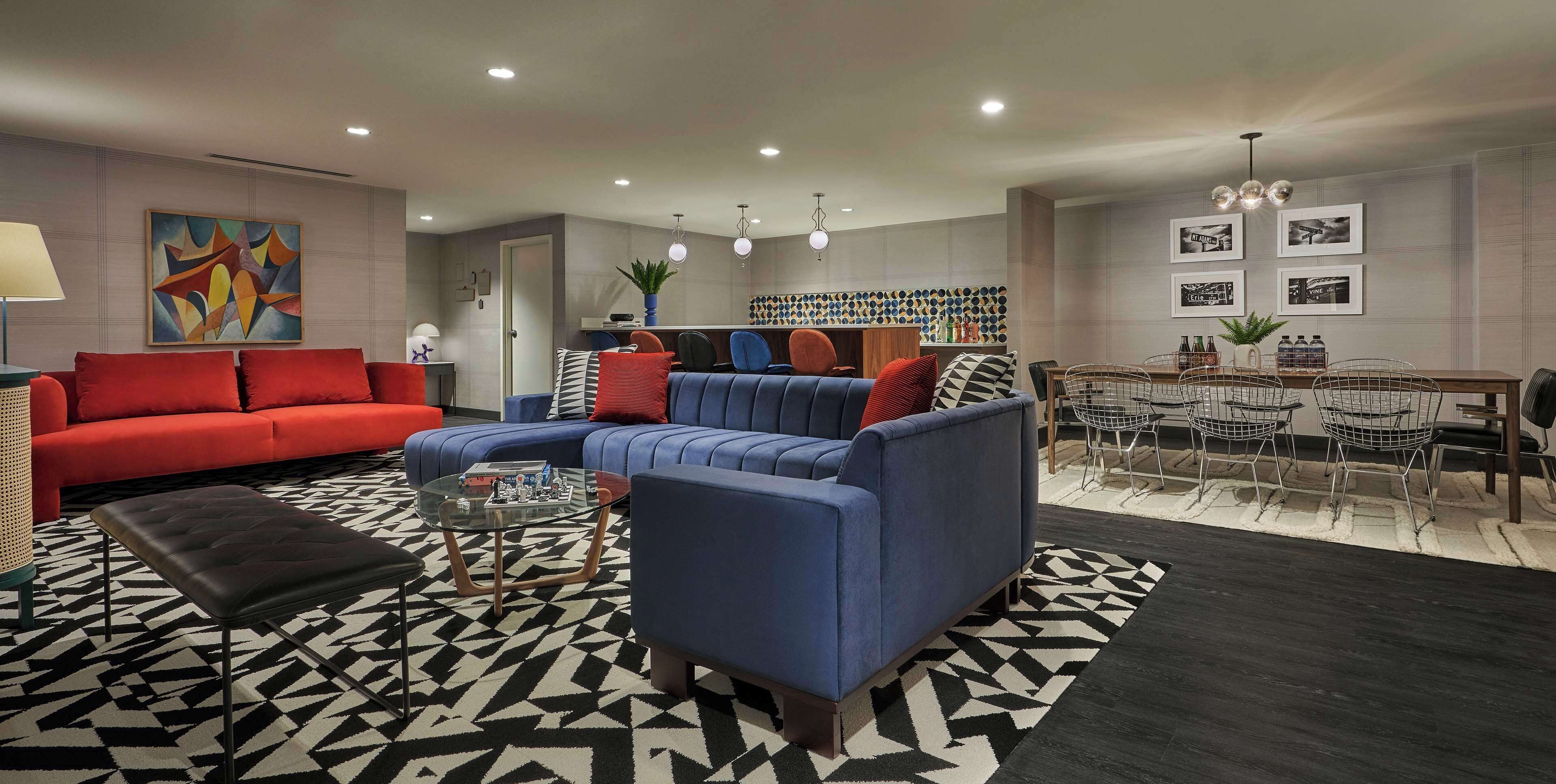 A modern living room with a sectional sofa, a coffee table, and a dining area with chairs and a table.