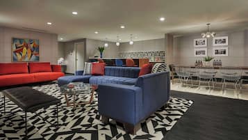 A modern living room with a sectional sofa, a coffee table, and a dining area with chairs and a table.
