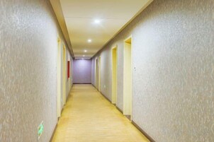 Un pasillo largo y estrecho en un hotel, con puertas a ambos lados que dan a las habitaciones.