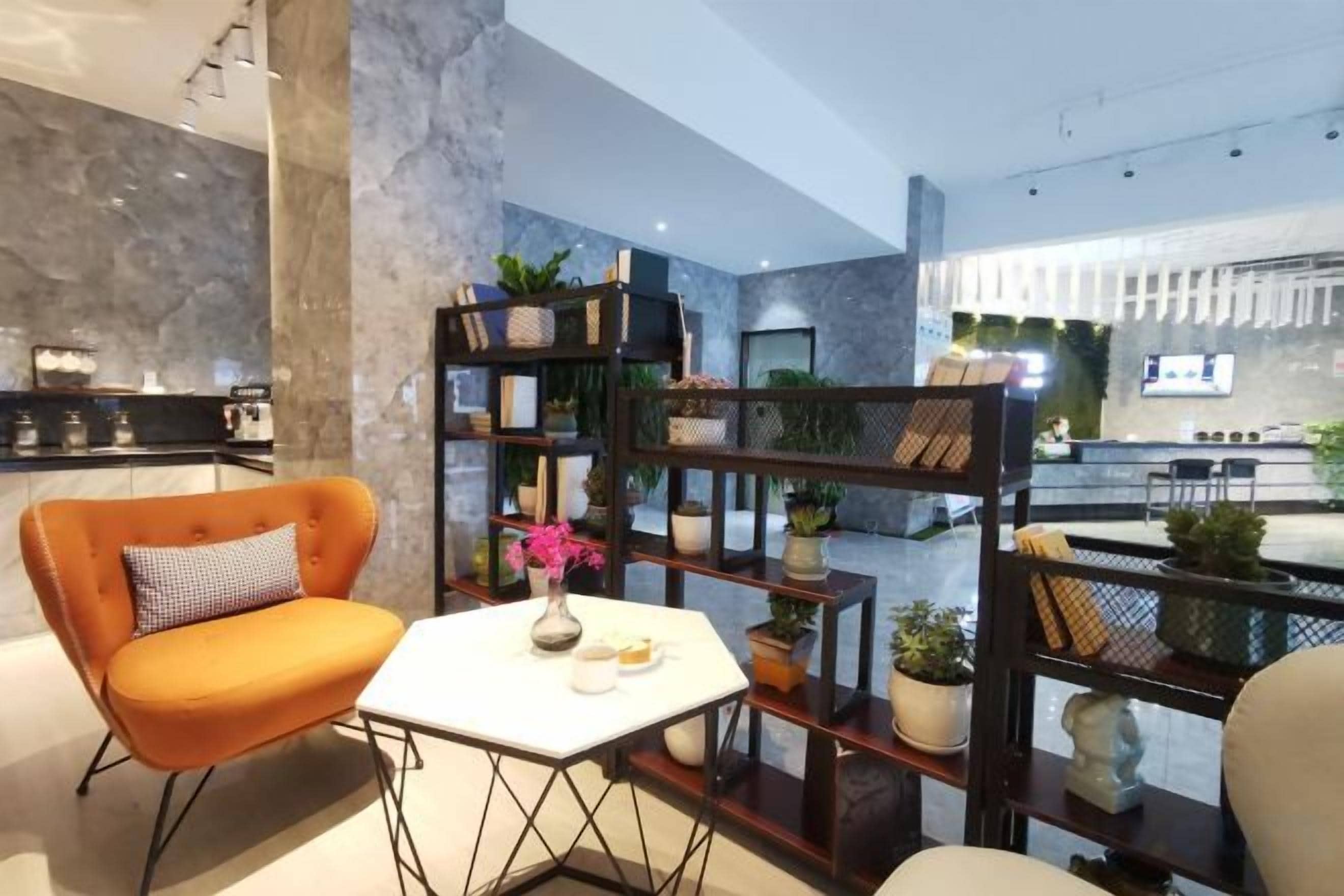 Un interior moderno con una zona de estar, una mesa blanca y una estantería decorativa.