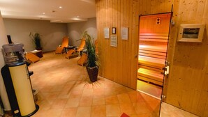 Ein Empfangsbereich mit Holzwand, Sauna und Sitzgelegenheiten mit Topfpflanzen.