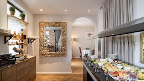 Ein Buffet mit verschiedenen Speisen, ein Spiegel mit aufwendiger Rahmenleiste und ein Holzboden.
