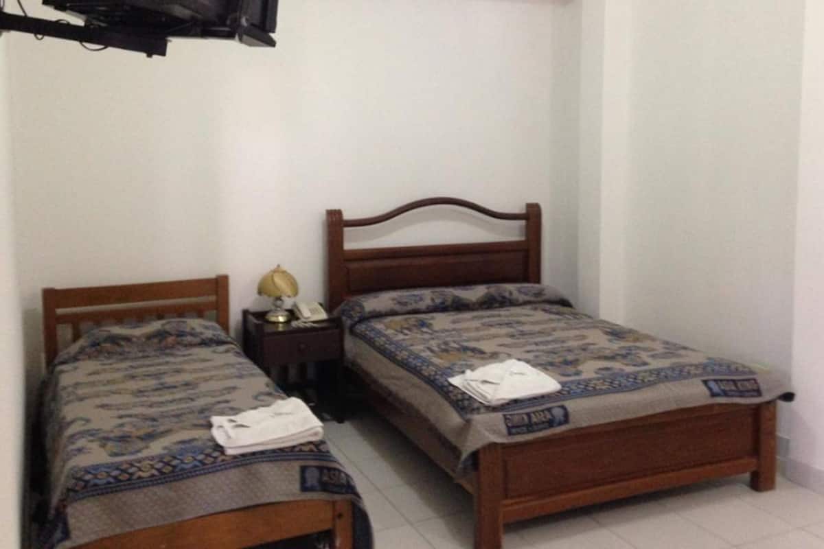 Habitación triple, varias camas, no fumadores | Tabla de planchar con plancha y ropa de cama