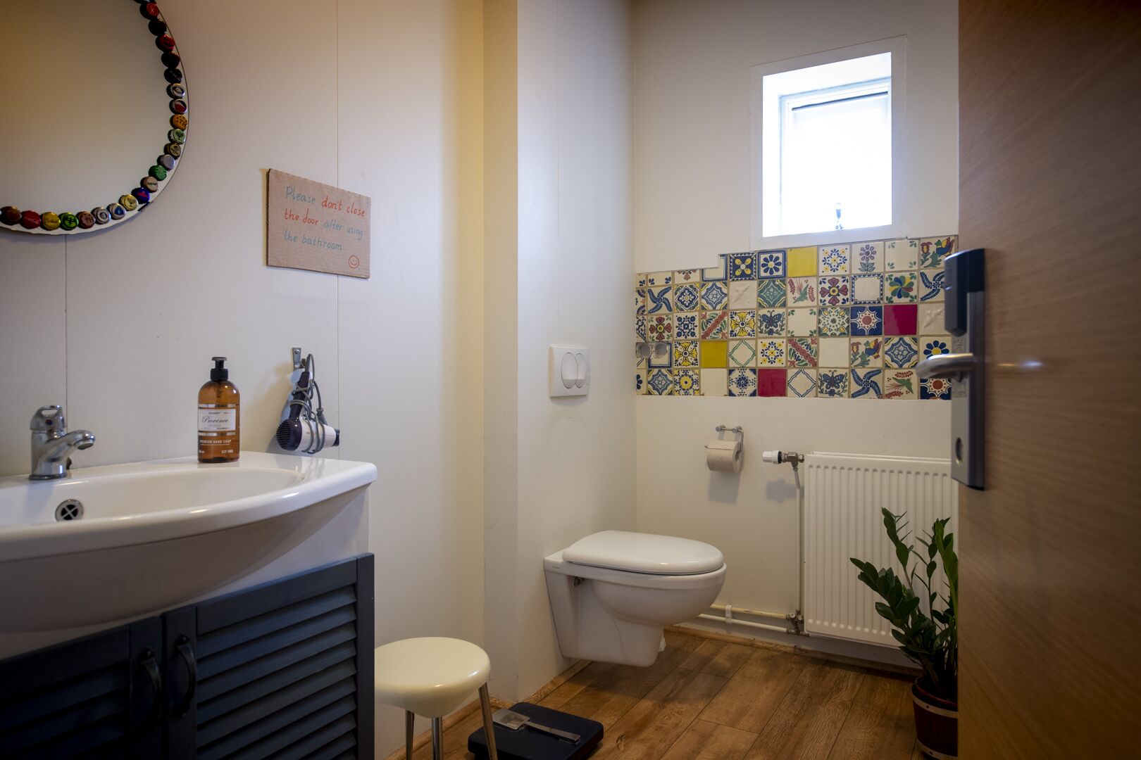 A bathroom with a sink, toilet, and a wall-mounted radiator.