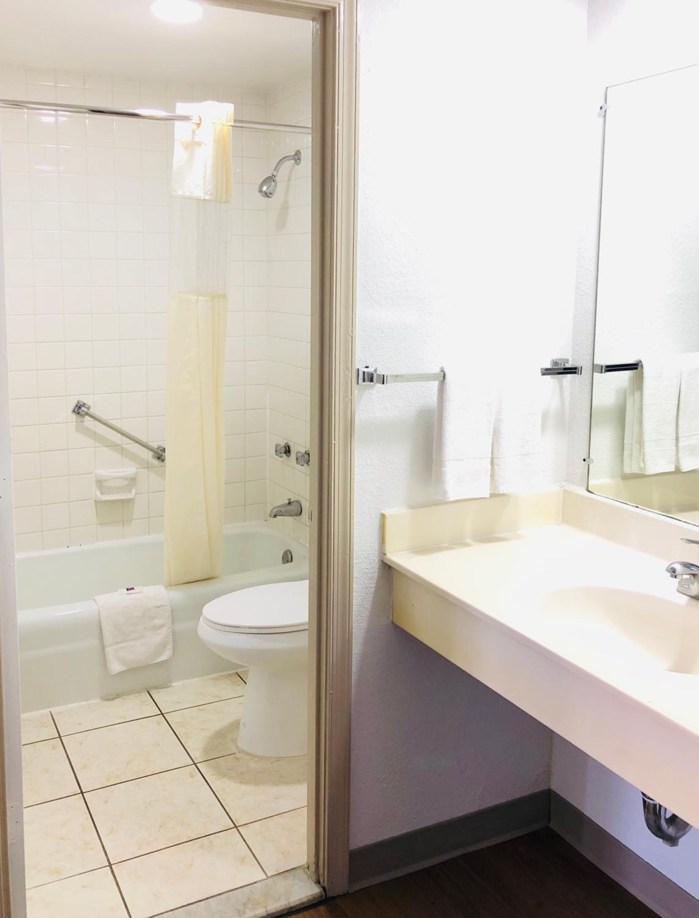 A bathroom with a bathtub, toilet, and sink.