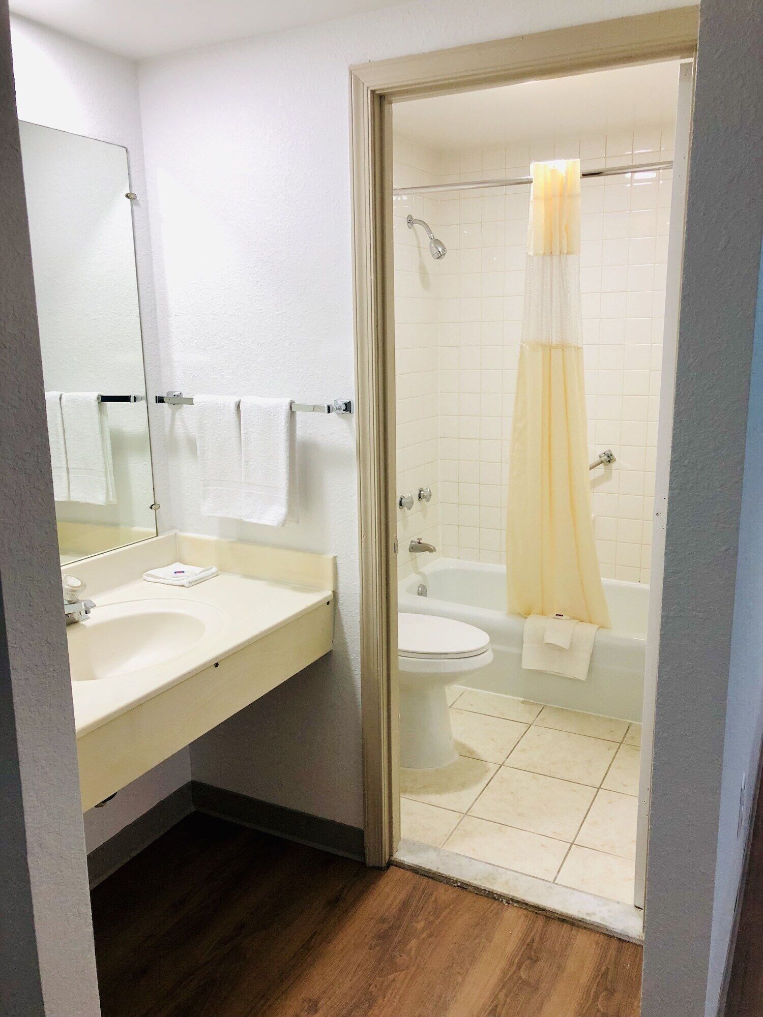 Un baño con lavamanos, espejo, inodoro y ducha.
