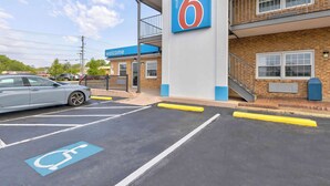 A motel with a blue and white exterior, a '6' sign, and a disabled parking space. - Motel 6 Falls Church, VA - Arlington Boulevard (Falls Church)