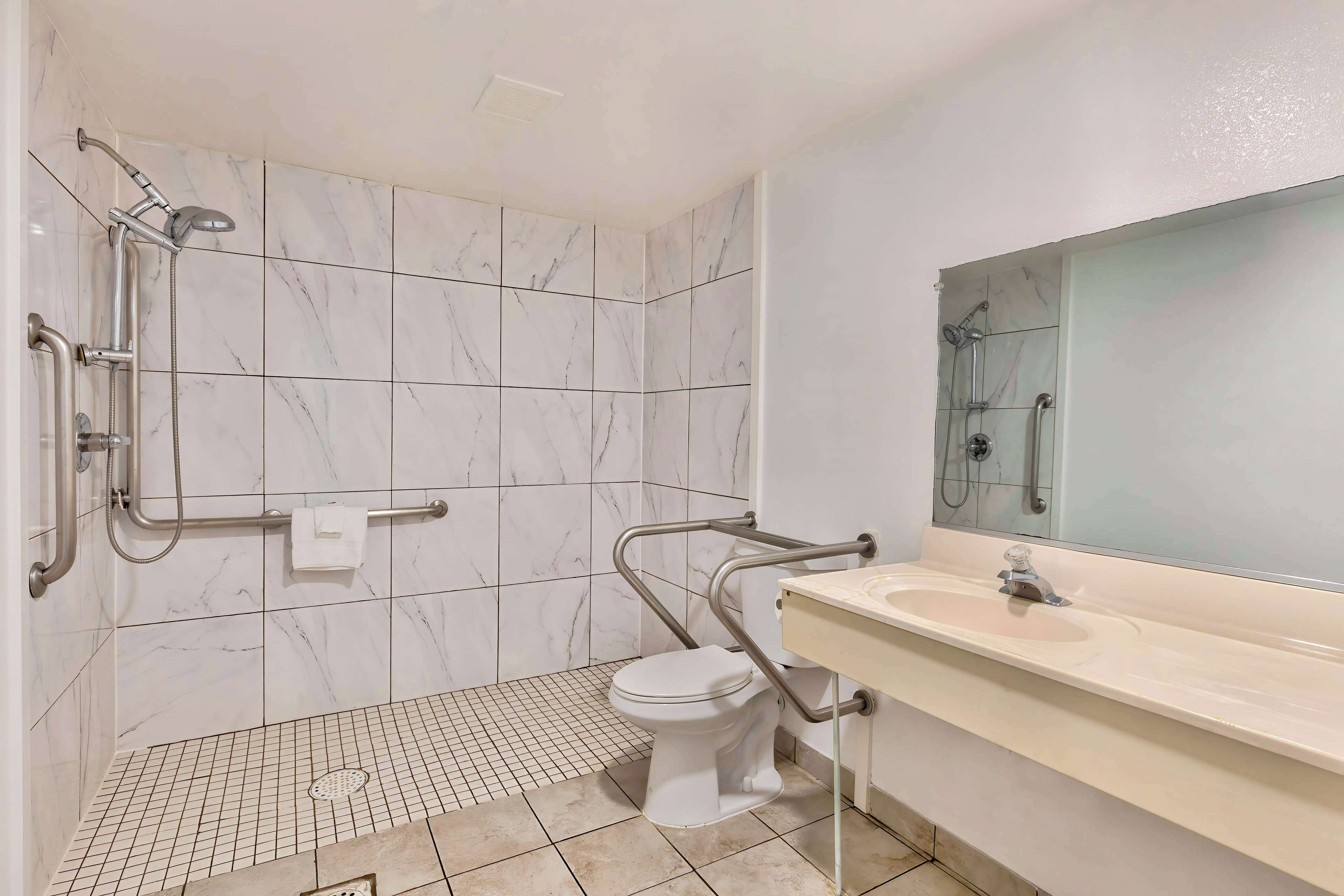 Une salle de bain comprenant des toilettes, un lavabo et un espace douche.