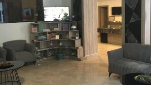 Una sala de estar moderna con dos sofás grises, una mesa de centro y una estantería.
