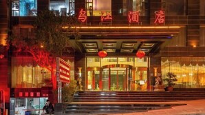 Ein Hotel Eingang mit moderner Fassade, beleuchteter Beschilderung und einladendem Zugang mit Stufen zum Eingang.