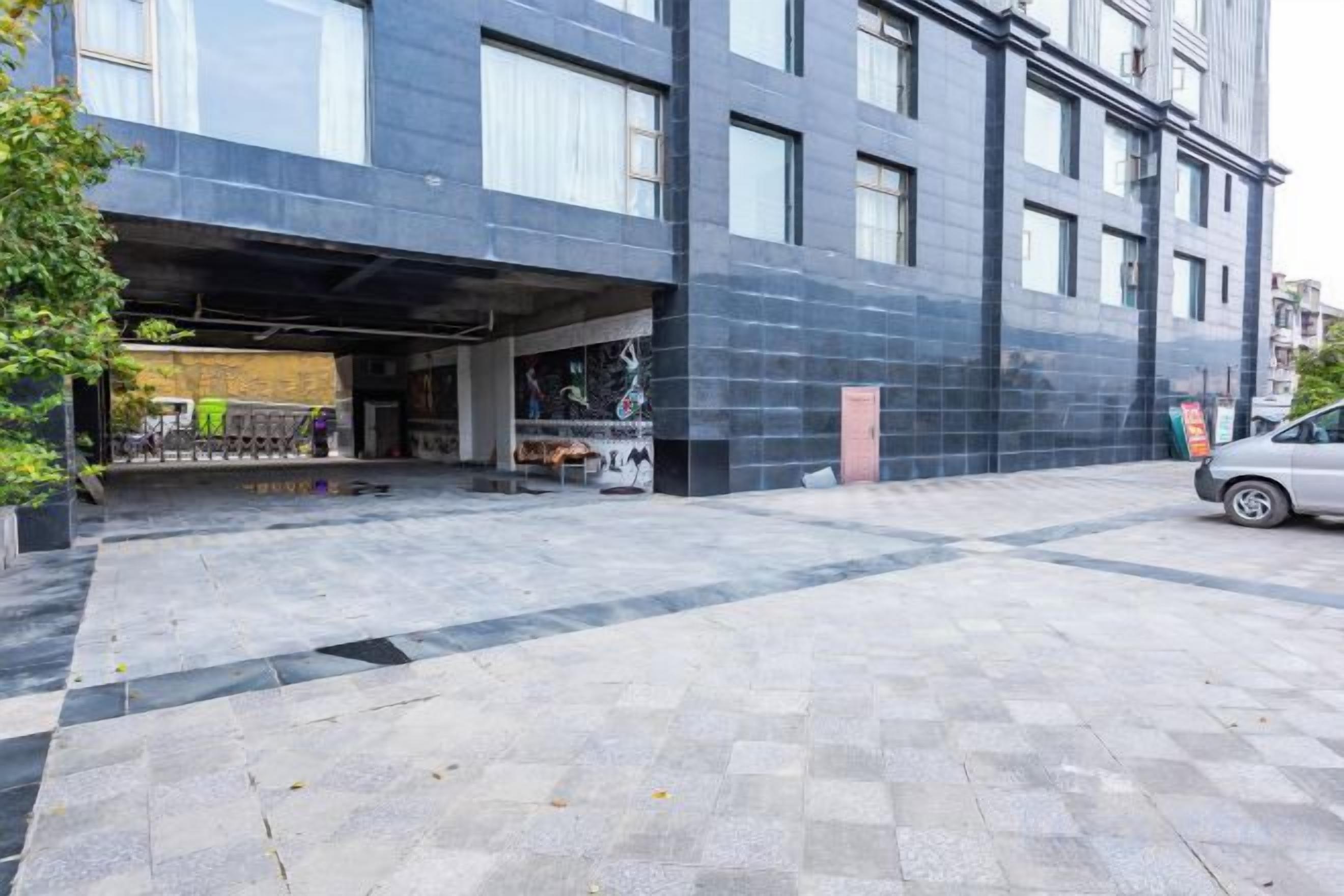 A modern building with a covered parking area and a paved walkway.