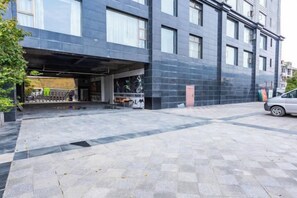 A modern building with a covered parking area and a paved walkway. - Wujiang Hotel (Yanhe)