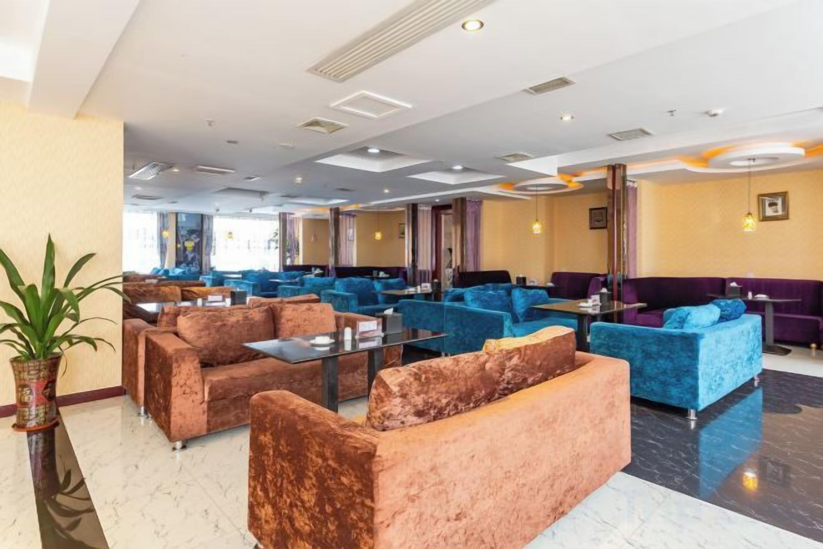 A hotel lobby with multiple seating areas, including sofas and armchairs, arranged in a spacious layout.