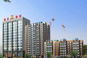 A multi-story residential building with balconies and a clear sky. - Wujiang Hotel (Yanhe)