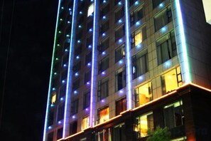 A multi-story building with illuminated vertical lines and windows. - Wujiang Hotel (Yanhe)