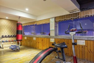 Un gimnasio con equipo de ejercicio, incluyendo un saco de boxeo y una bicicleta estática.