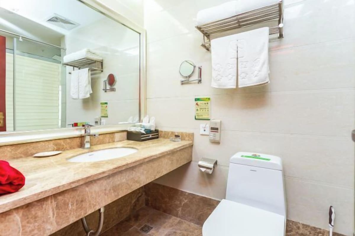A bathroom with a sink, mirror, towel rack, and toilet.