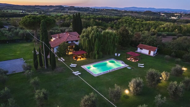 An aerial view of a property with a swimming pool, two houses, and surrounding greenery. - Villa Leonardo (Sarteano)