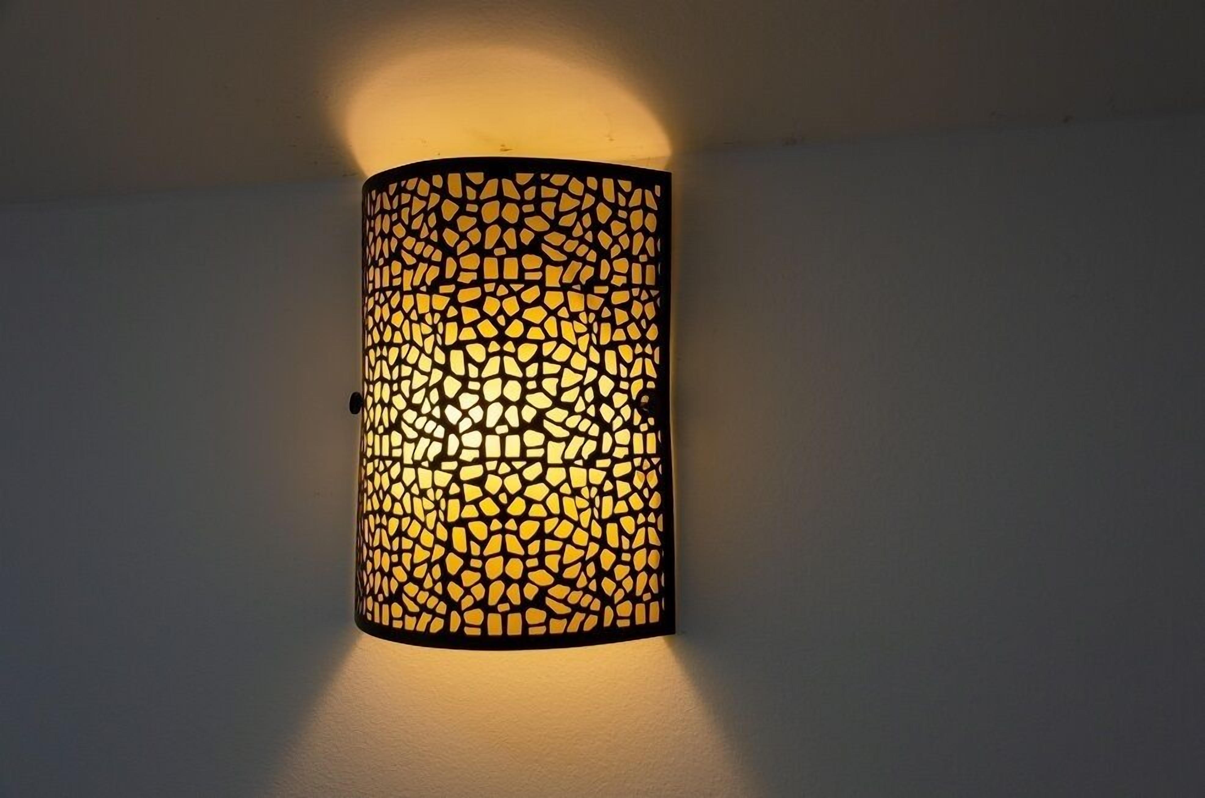 A wall-mounted cylindrical light fixture with a mosaic pattern.