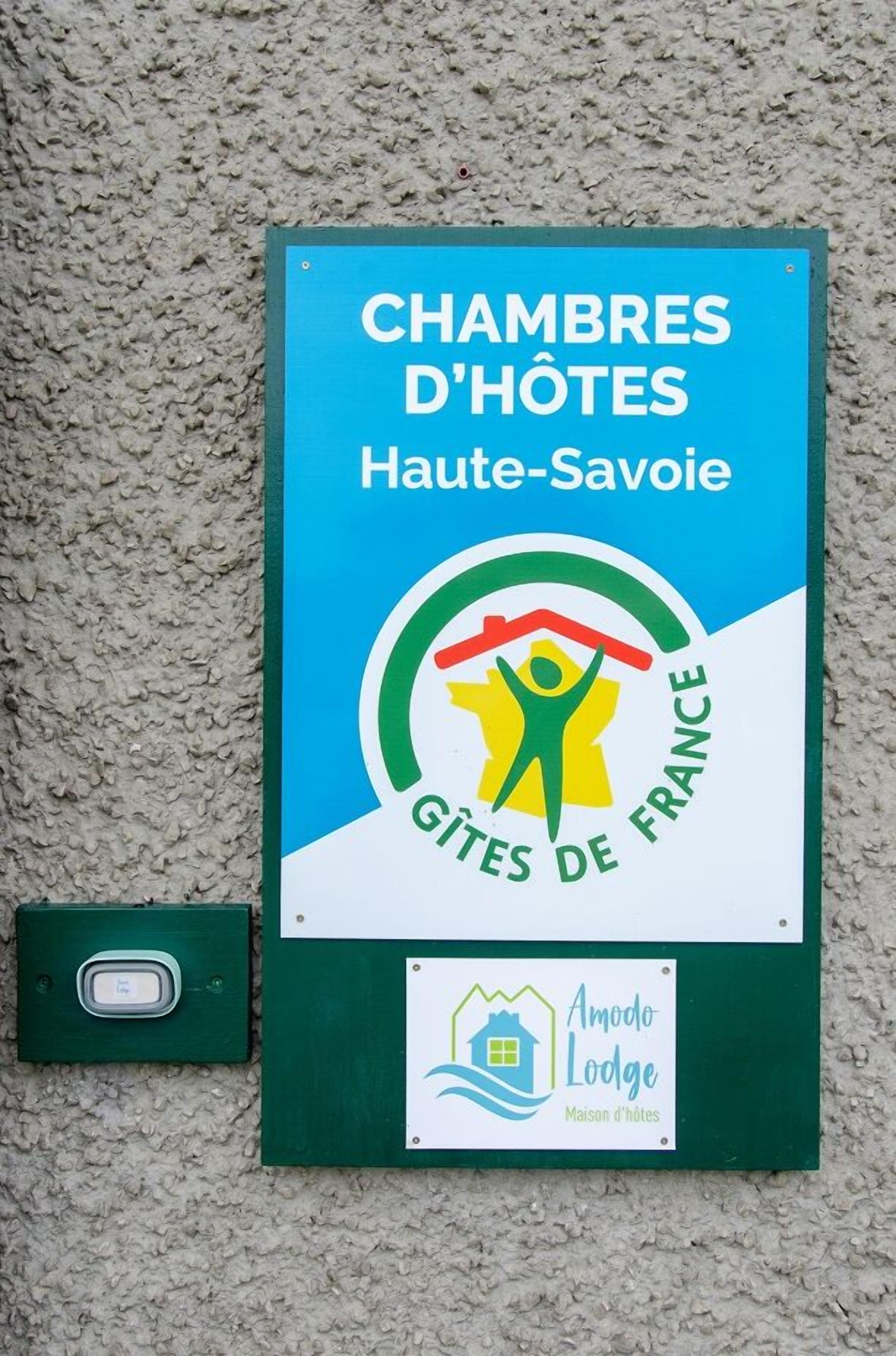 A sign for Chambres d'Hôtes Haute-Savoie, featuring a logo with a person holding a house and the text "Gîtes de France".