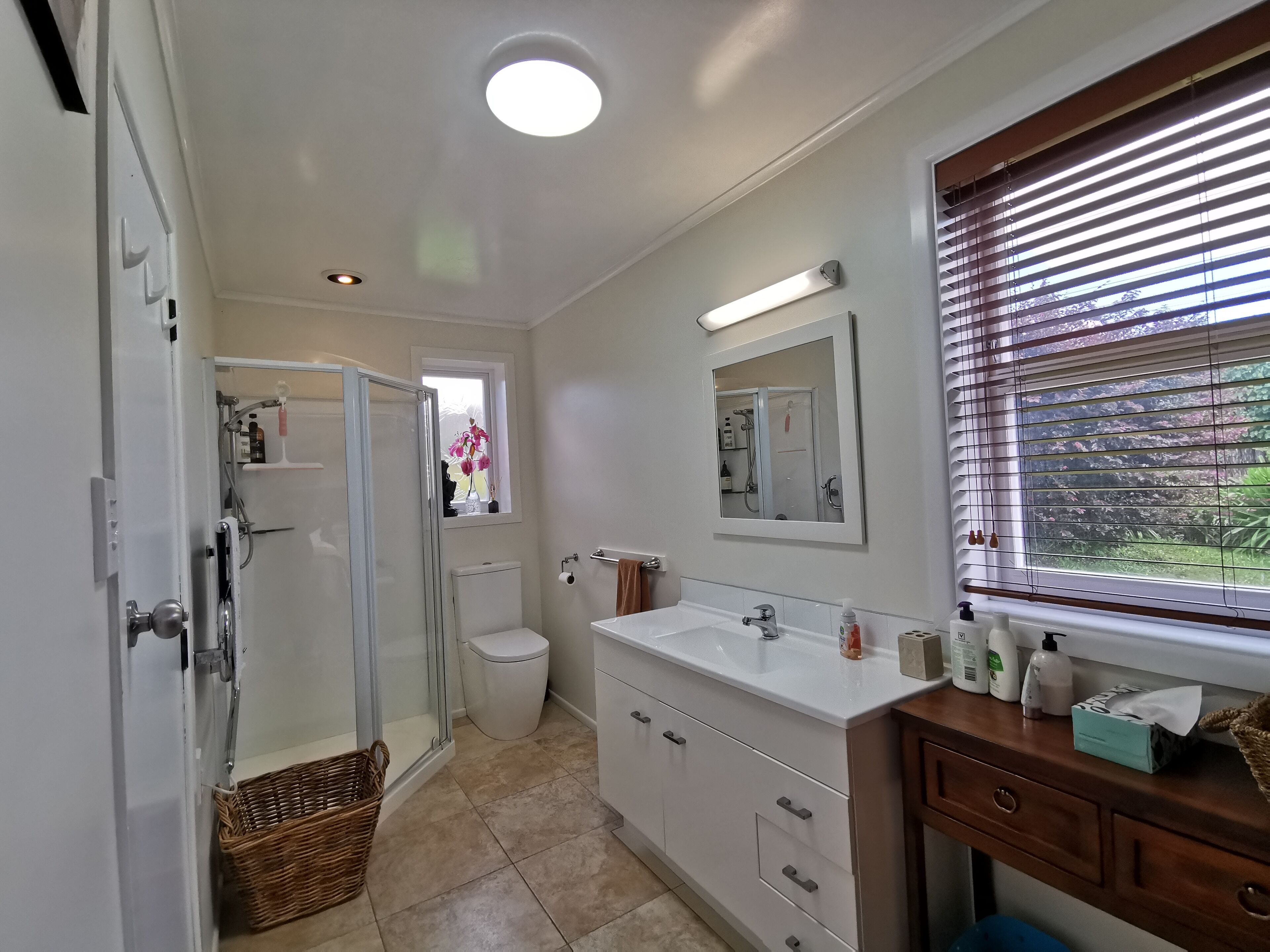 A modern bathroom with a shower, toilet, and sink area.