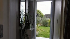 A hallway with a door leading to a garden. - Geyser Lookout BnB (Rotorua)